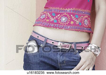 Mid section view of a woman with a mobile phone in her pocket View Large Photo Image Stock Photography - Mid section view of a woman with a mobile phone in her pocket. Fotosearch