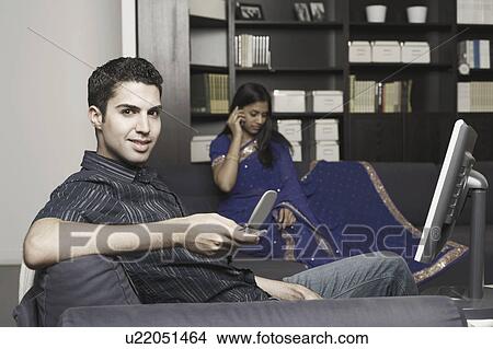 Portrait of a young man holding a mobile phone View Large Photo Image Picture - Portrait of a young man holding a mobile phone. Fotosearch