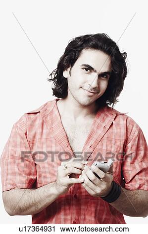 Portrait of a young man holding a mobile phone View Large Photo Image Stock Image - Portrait of a young man holding a mobile phone. Fotosearch