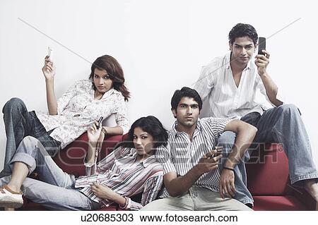 Portrait of two young couples holding mobile phones View Large Photo Image Stock Image - Portrait of two young couples holding mobile phones. Fotosearch