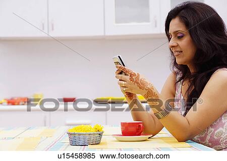 Side profile of a mid adult woman operating a mobile phone View Large Photo Image Stock Photography - Side profile of a mid adult woman operating a mobile phone. Fotosearch