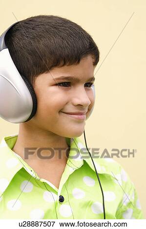 Close-up of a boy wearing headphones and smirking View Large Photo Image Stock Photo - Close-up of a boy wearing headphones and smirking. Fotosearch