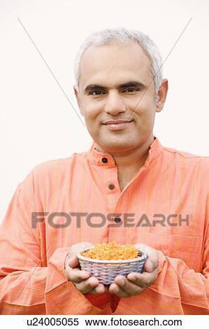 Close-up of a mid adult man holding a bowl of flowers View Large Photo Image Stock Photography - Close-up of a mid adult man holding a bowl of flowers. Fotosearch