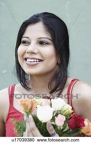 Close-up of a young woman holding a bouquet of flowers View Large Photo Image Stock Image - Close-up of a young woman holding a bouquet of flowers. Fotosearch