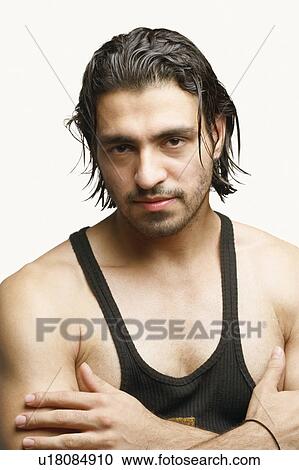 Stock Image - Portrait of a young man with his arms folded. Fotosearch