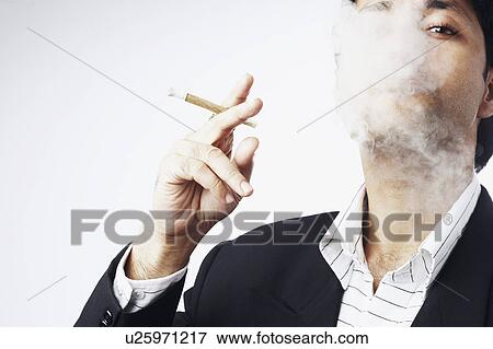 Stock Photo - Portrait of a businessman smoking a cigar. Fotosearch