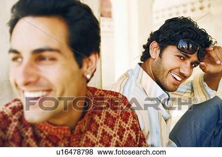 Portrait of a young man sitting with another young man behind him View Large Photo Image Stock Photo - Portrait of a young man sitting with another young man behind him. Fotosearch