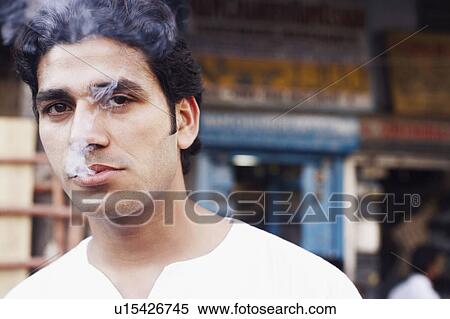 Portrait of a young man smoking View Large Photo Image Stock Photography - Portrait of a young man smoking. Fotosearch