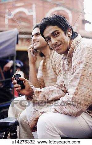 Stock Image - Two young men sitting in a rickshaw. Fotosearch