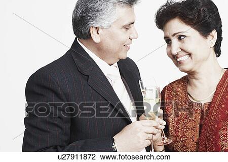 Close-up of a mature couple toasting with champagne flutes View Large Photo Image Stock Image - Close-up of a mature couple toasting with champagne flutes. Fotosearch