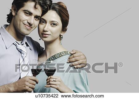 Stock Image - Portrait of a young couple holding wineglasses. Fotosearch