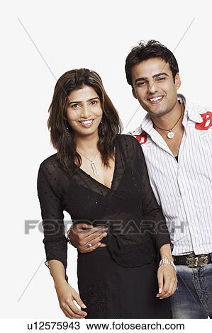 Portrait of a young couple standing and smiling View Large Photo Image Stock Image - Portrait of a young couple standing and smiling. Fotosearch