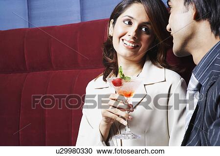 Close-up of a businesswoman sitting with a businessman and holding a glass of martini View Large Photo Image Stock Image - Close-up of a businesswoman sitting with a businessman and holding a glass of martini. Fotosearch