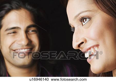 Stock Image - Close-up of a young couple smiling. Fotosearch