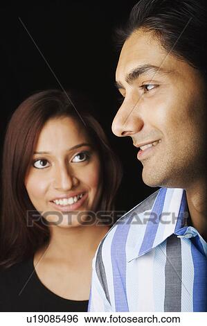 Stock Photograph - Close-up of a young couple smiling. Fotosearch