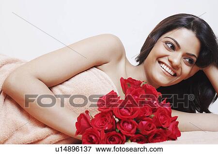 Stock Photo - Close-up of a young woman holding a bouquet of flowers and smiling. Fotosearch