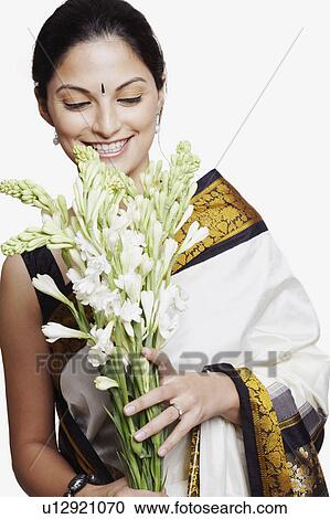 Close-up of a young woman wearing a sari and holding a bunch of flowers View Large Photo Image Stock Image - Close-up of a young woman wearing a sari and holding a bunch of flowers. Fotosearch