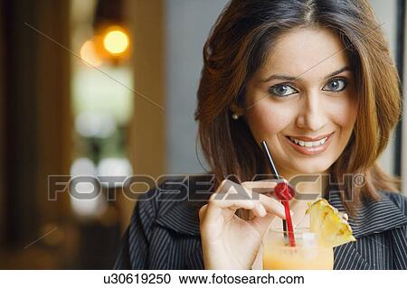 Portrait of a businesswoman holding a glass of cocktail View Large Photo Image Stock Image - Portrait of a businesswoman holding a glass of cocktail. Fotosearch