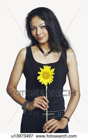 Stock Photo - Portrait of a mid adult woman holding a sunflower. Fotosearch