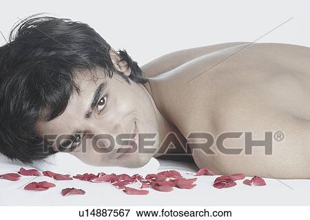 Stock Photo - Portrait of a young man lying on a massage table. Fotosearch
