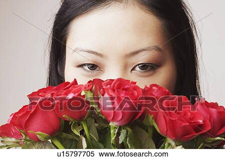 Stock Photography - Portrait of a young woman holding a bouquet of roses. Fotosearch