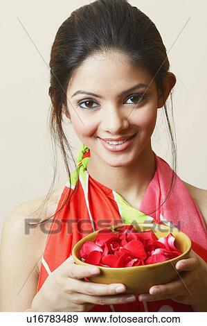 Portrait of a young woman holding rose petals in a bowl View Large Photo Image Stock Photo - Portrait of a young woman holding rose petals in a bowl. Fotosearch