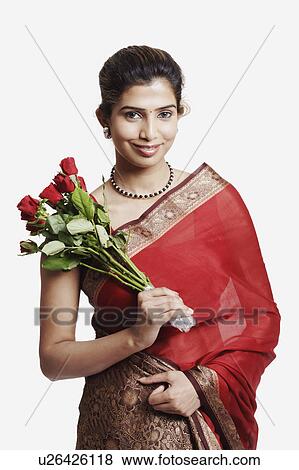 Stock Photo - Portrait of a young woman wearing a sari and holding a bunch of flowers. Fotosearch
