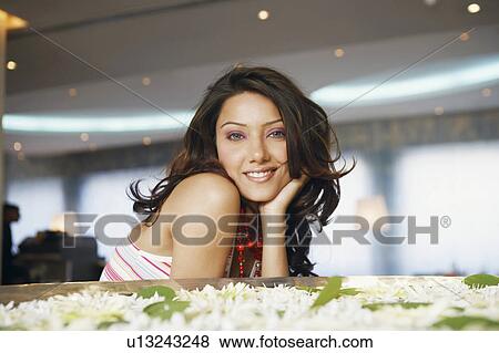 Stock Photo - Portrait of a young woman with her hand on her chin. Fotosearch