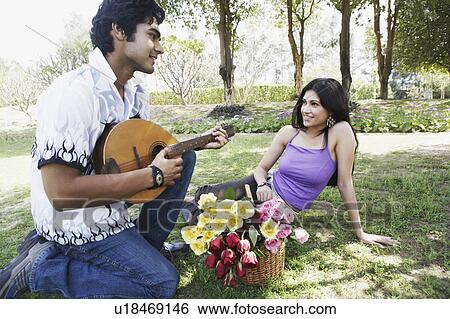 Young man playing the mandolin with a young woman looking at him View Large Photo Image Stock Photograph - Young man playing the mandolin with a young woman looking at him. Fotosearch