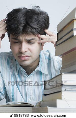 Close-up of a young man reading a book and looking worried View Large Photo Image Stock Image - Close-up of a young man reading a book and looking worried. Fotosearch