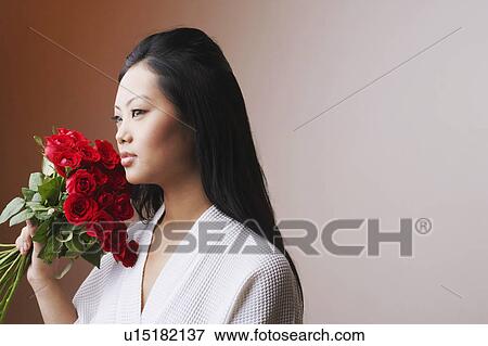 Close-up of a young woman holding a bouquet of roses and thinking View Large Photo Image Stock Photo - Close-up of a young woman holding a bouquet of roses and thinking. Fotosearch