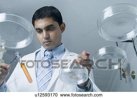 Low angle view of a scientist examining a solution in a test tube View Large Photo Image Stock Image - Low angle view of a scientist examining a solution in a test tube. Fotosearch