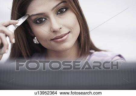 Portrait of a businesswoman holding a mobile phone View Large Photo Image Picture - Portrait of a businesswoman holding a mobile phone. Fotosearch