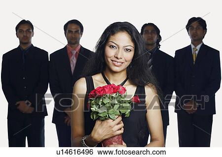 Stock Photograph - Portrait of a young woman holding a bouquet of flowers with four businessmen standing behind her. Fotosearch