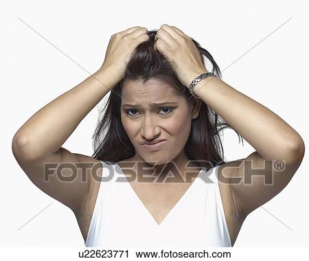 Stock Image - Portrait of a young woman pulling her hair. Fotosearch