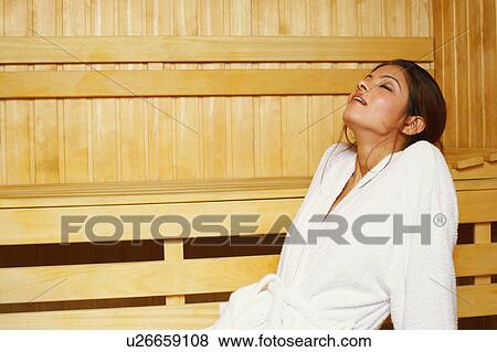 Stock Photo - Side profile of a young woman sitting in a sauna. Fotosearch