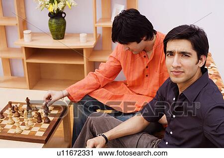 Two young men playing chess View Large Photo Image Stock Image - Two young men playing chess. Fotosearch