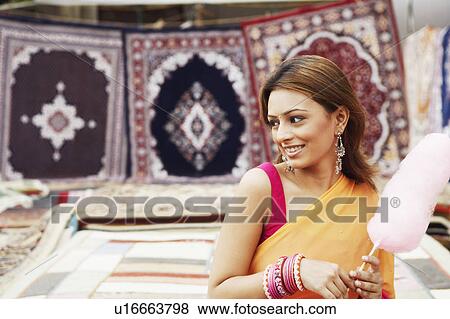 Stock Photo - Close-up of a young woman holding cotton candy. Fotosearch
