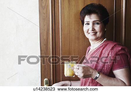 Stock Image - Portrait of a mature woman holding a tea cup. Fotosearch