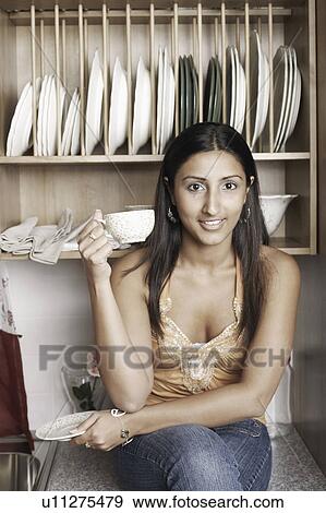 Portrait of a young woman holding a cup of coffee View Large Photo Image Stock Photo - Portrait of a young woman holding a cup of coffee. Fotosearch
