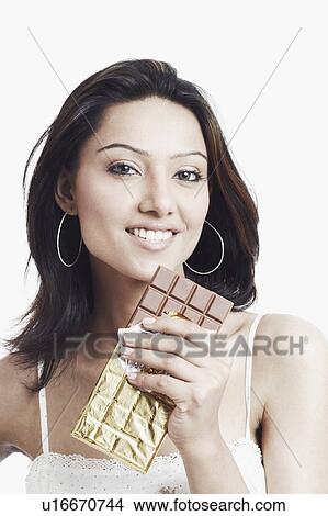 Portrait of a young woman holding a slab of chocolate View Large Photo Image Picture - Portrait of a young woman holding a slab of chocolate. Fotosearch