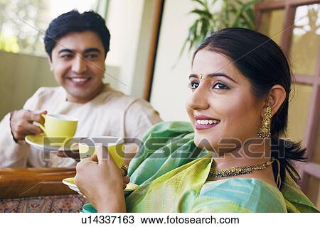 Young couple holding cups of tea View Large Photo Image Stock Image - Young couple holding cups of tea. Fotosearch