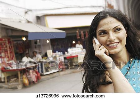 Stock Photograph - Close-up of a young woman talking on a mobile phone. Fotosearch