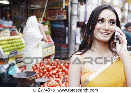 Close-up of a young woman talking on a mobile phone View Large Photo Image Stock Photography - Close-up of a young woman talking on a mobile phone. Fotosearch