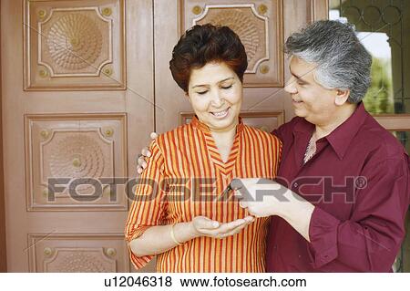 Close-up of a mature man giving car keys to a mature woman View Large Photo Image Stock Photo - Close-up of a mature man giving car keys to a mature woman. Fotosearch