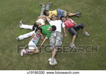High angle view of a family lying on ground and smiling View Large Photo Image Stock Image - High angle view of a family lying on ground and smiling. Fotosearch