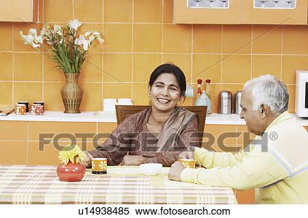 Stock Photography - Mature couple having tea at the dining table. Fotosearch