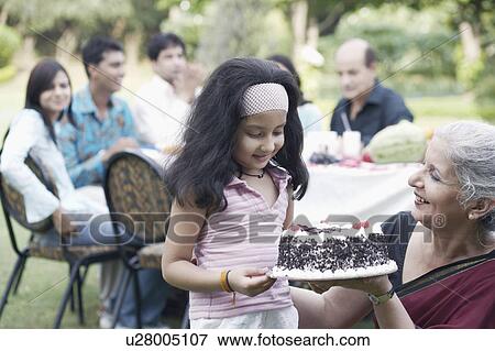 Mature woman and a girl holding a cake View Large Photo Image Stock Photo - Mature woman and a girl holding a cake. Fotosearch