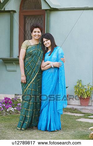 Stock Photo - Portrait of a mature woman with her arm around her daughter. Fotosearch