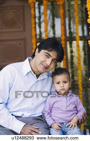 Stock Image - Portrait of a young man sitting with his daughter. Fotosearch